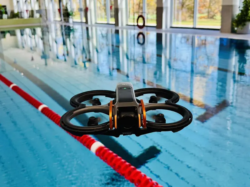 FPV-Drohne über dem Wasser in einem Hallenbad