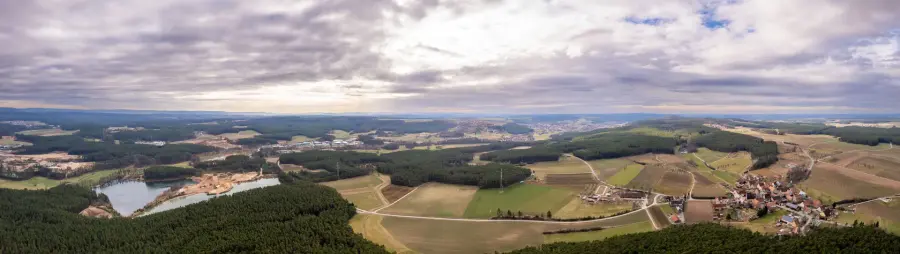 Weite Landschaft mit Wäldern und See von oben